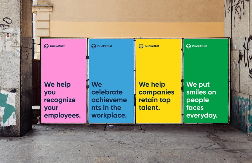 Four Bucketlist billboards in pink, blue, yellow and green carrying recognition messages