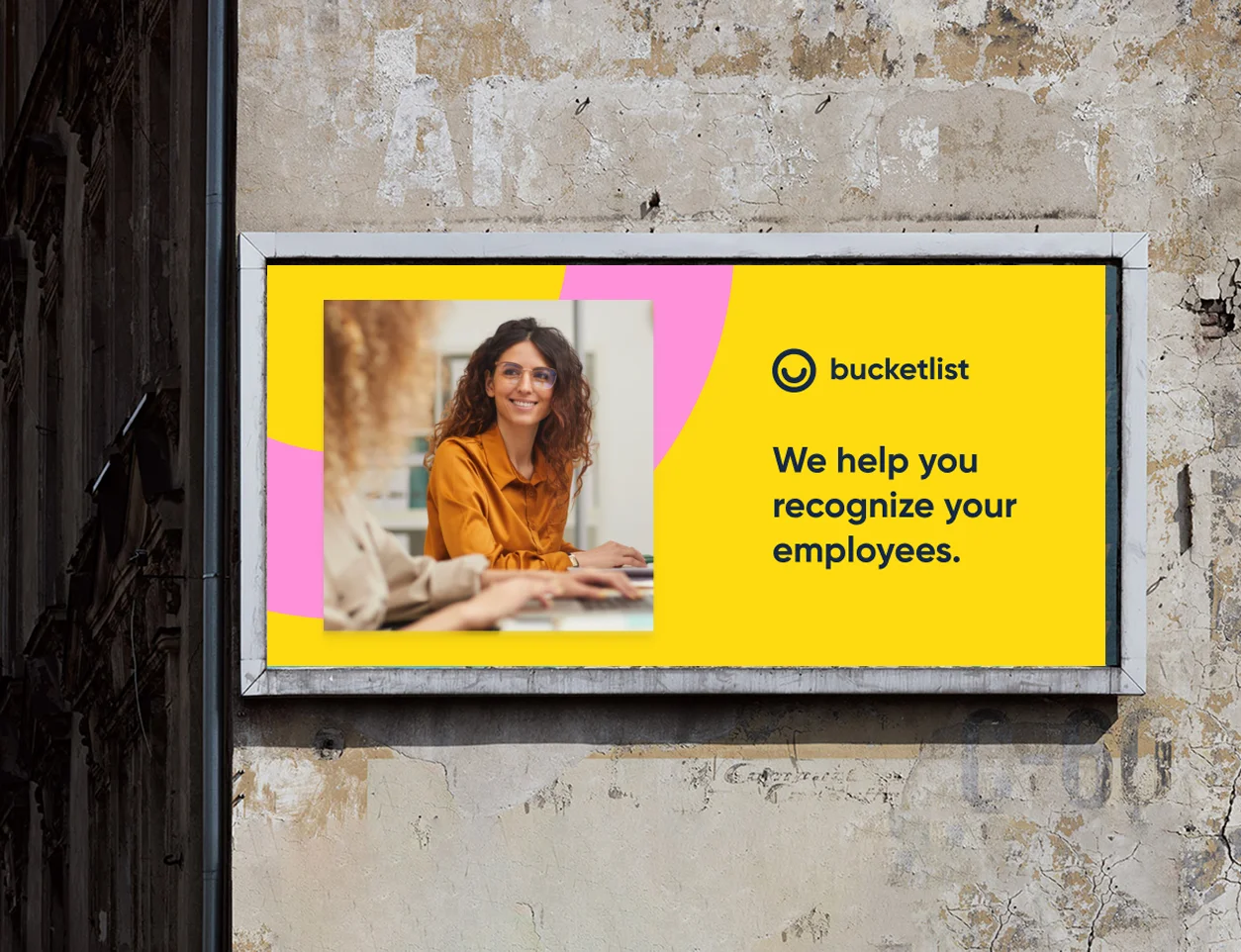 Bucketlist campaign poster on a weathered wall: We help you recognize your employees